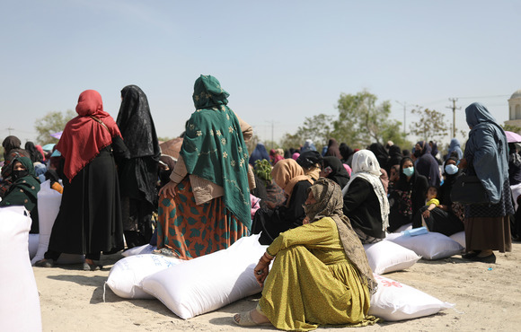 Women receive sacks of rice sent by China at a Kabul distribution centre in April 2022. Between July 2021 and March 2022, the number of Afghans facing acute hunger rose from 14 million to 23 million. 
