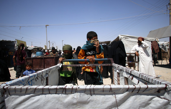 Two Iraqi children pull a cart through the market in al-Hol camp, which lies east of al-Hasakeh city, in northeastern Syria.