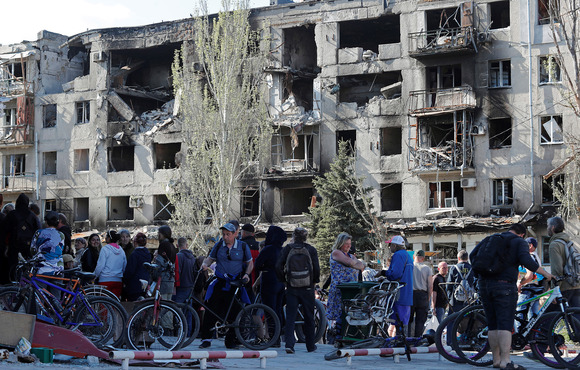 Residents of Mariupol, a port in eastern Ukraine, gather to receive humanitarian aid on 28 April 2022. The city became fully occupied by Russian forces in early May after a months-long siege.